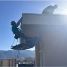 operai di Dinamica sospesi in un opera edilizia acrobatica ristrutturano un cornicione