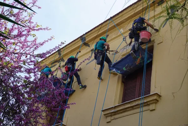 quattro operai lavorano sospesi su corde a Palermo