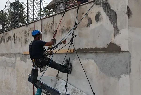operaio esperto di edilizia acrobatica su corda si cala da un tetto