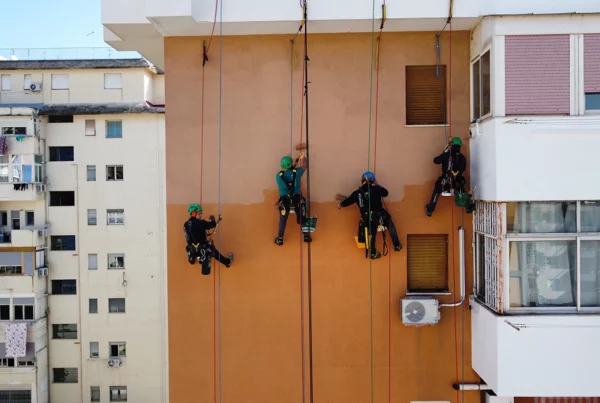 operai ridipingono palazzo senza impalcature grazie alle corde